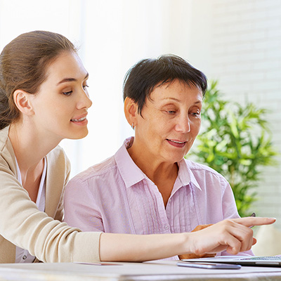 A senior woman being assisted with her computer 