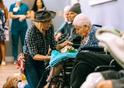 A woman handing a resident a bunny at Glendale Healthcare Center