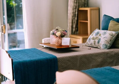 A resident's bedside with flowers and papers at Glendale Healthcare Center
