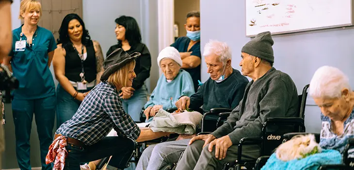 A woman showing a bunny to elderly residents at Glendale