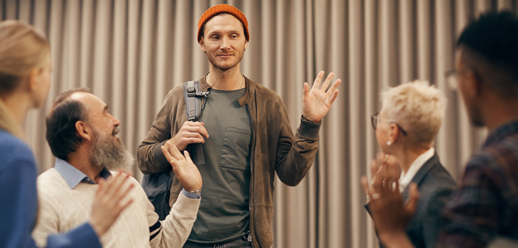 man waving goodbye to seated group