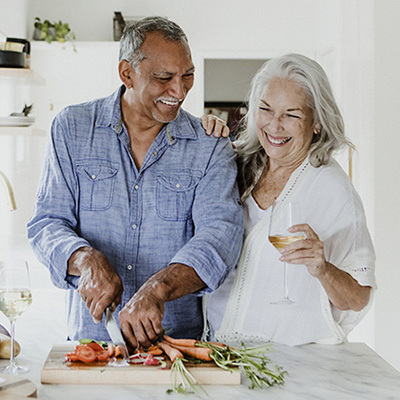 Two seniors cooking together in a kitchen.