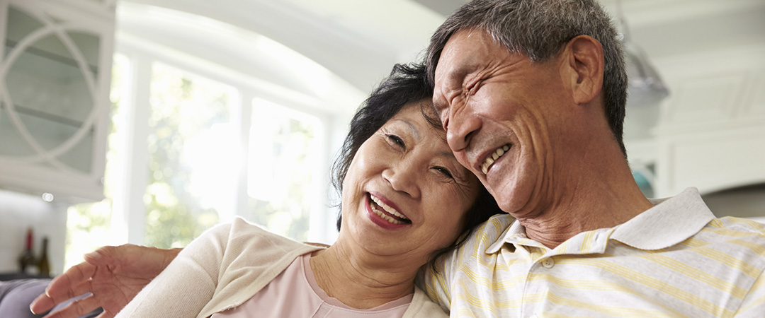 A smiling, happy Asian American couple at home