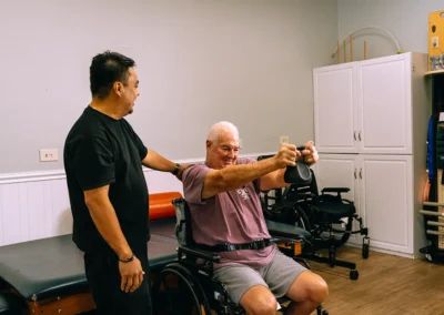 An elderly man lifting a weight at Casitas Care Center