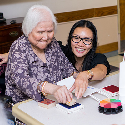 a caregiver with an elderly resident working on activities