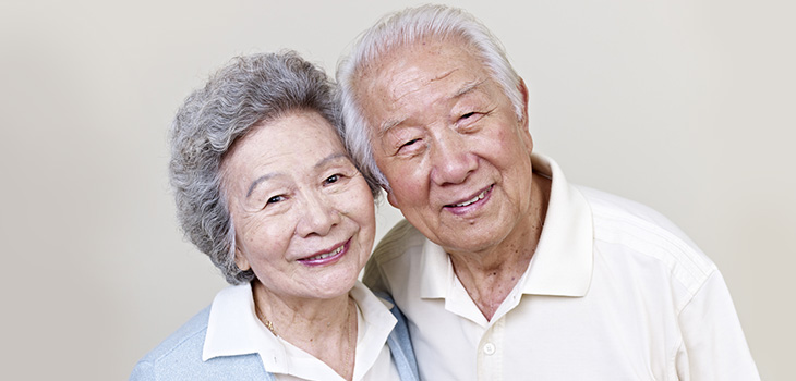 A senior couple arm embracing each other and smiling.