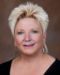 Sandy Haskins 2020 administrator of the year woman with short blonde hair and black top