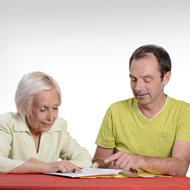 Nurse smiling at a seated resident and he is smiling back at her