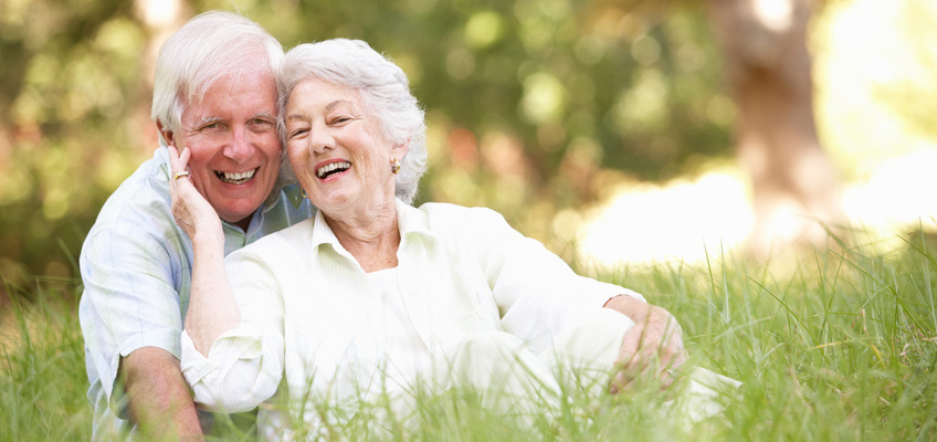 The Pointe at Morris community with a walking path surrounded by lush grass and trees A couple smiling together and sitting in tall grass.
