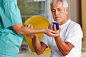 A senior and a specialist working on rehabilitation exercises together.