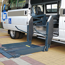 A handicapped van with wheelchair ramp exposed.