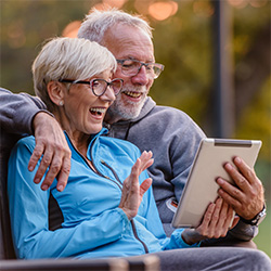 Two seniors looking at a laptop together.