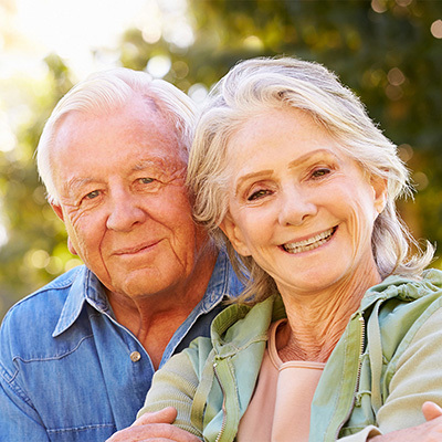 A couple smiling together in a park.