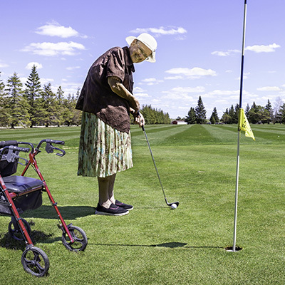 A senior at a golf course playing golf.