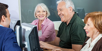 A group of seniors working on a computer together.