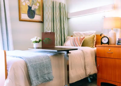 A resident's bed with a painting on the wall Mountain View