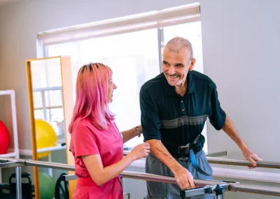 A physical therapist helping an elderly man walk at Mountain View